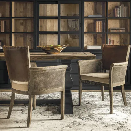 Poltroncina Anne con struttura in legno massello di Rovere, seduta imbottita rivestita in tessuto, schienale imbottito e rivestito in vera pelle con rilegatura in cuoio intrecciato e braccioli in cannettato intrecciato di Dialma Brown