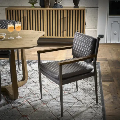 Sedia Baltimora in vera pelle trapuntata con braccioli in legno e struttura in metallo di Dialma Brown